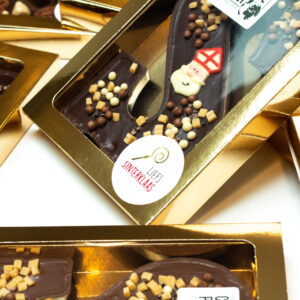 Verschillende chocoladeletters van Chocolate Planet in melk en pure chocolade, met vullingen zoals salted caramel en hazelnootpraliné.